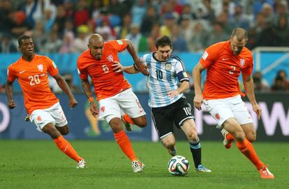 Lionel Messi se abra paso entre los jugadores holandeses Georginio Wijnaldum, Nigel de Jong y Ron Vlaar (de izda a dcha).