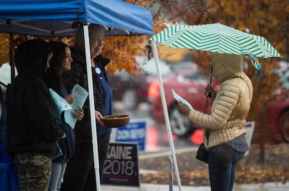 Voluntarios del partido demócrata hablan a los votantes a las afueras de un colegio electoral en Virginia (EE UU). Los estadounidenses participan hoy en unas eleciones legislativas críticas que ponen en juego el control del Congreso.