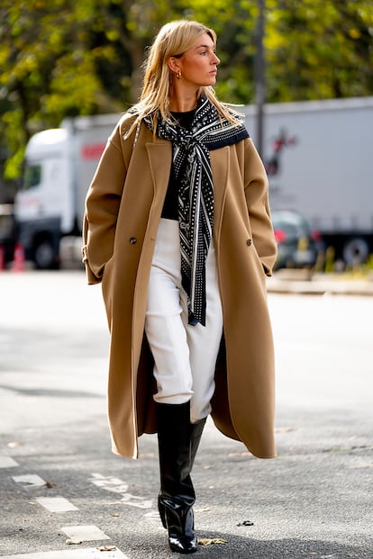 Un simple pañuelo puede transformar un look por completo. Más allá del fular enrollado en el cuello, colocar un pañuelo sobre los hombros y anudarlo en el centro logra un resultado sofisticado y un poco retro (la abuela como icono inspirador de la moda se resiste a desaparecer). La prueba la tiene la influencer y podcaster Camille Charriere con su pañuelo de Hermès.