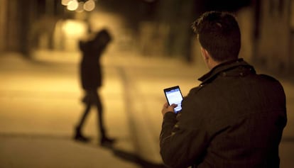  Un joven envía mensajes con su teléfono móvil