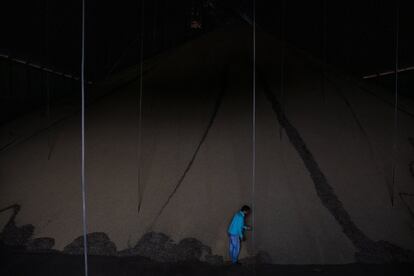 Un trabajador junto a una inmensa montaña de soja almacenada en las afueras de la ciudad de Sinop, una región que es la cuna del agronegocio y de una pujante clase empresarial.