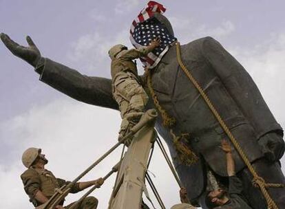 Soldados de EE UU cubren con la bandera de su país la cara de la estatua de Sadam Husein, antes de derribarla el 9 de abril de 2003.