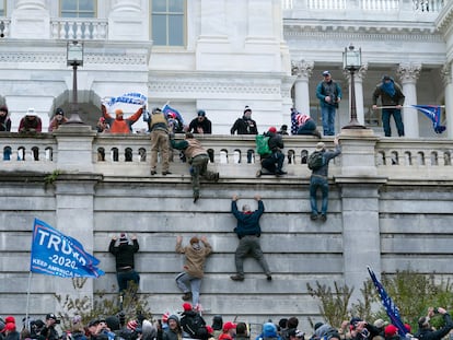 Partidarios de Donald Trump escalan la pared oeste del Capitolio de Estados Unidos, en Washington (EE UU).