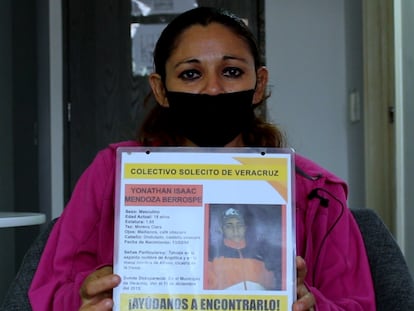 Angélica Berrospe sujeta el cartel de búsqueda de su hijo Yonathan Mendoza, desaparecido en Veracruz en 2013.