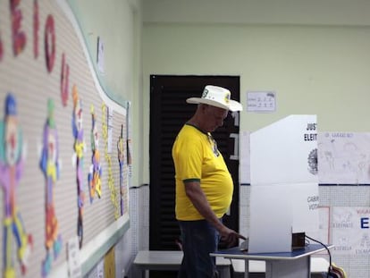 Un hombre con camisa amarilla vota en una escuela en Brasilia.