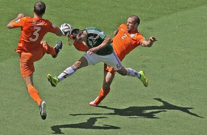 Héctor Herrera (c) pugna por el balón con De Vrij (i) y Vlaar.