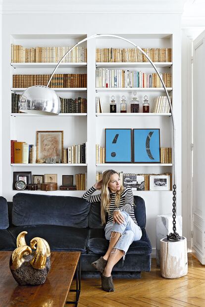 De Libran, con jersey y sandalias de Sonia Rykiel y vaqueros japoneses vintage, posa en su sofá de terciopelo azul, junto a la lámpara de Willy Rizzo.