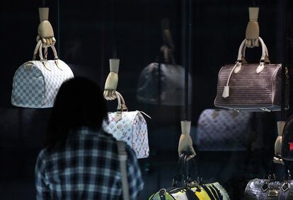 Una mujer contempla unos bolsos históricos de la exposición 'Voyages', en homenaje a Louis Vuitton, en China.