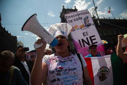 Una manifestante con un megáfono corea consignas en favor al INE y en contra del Gobierno de López Obrador, durante la protesta de este domingo.