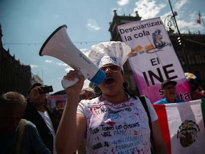 Una manifestante con un megáfono corea consignas en favor al INE y en contra del Gobierno de López Obrador, durante la protesta de este domingo.