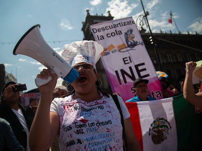 Una manifestante con un megáfono corea consignas en favor al INE y en contra del Gobierno de López Obrador, durante la protesta de este domingo.