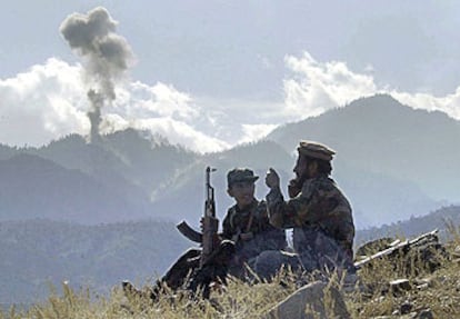 Dos <b><i>muyahidin</b></i> charlan mientras observan el humo de las bombas lanzadas contra Tora Bora, en la pasada guerra afgana.