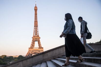Dos personas caminan por el barrio del Trocadero con la Torre Eiffel al fondo, en París. Francia tiene a 180.051 personas infectadas con coronavirus y 28.242 víctimas mortales.