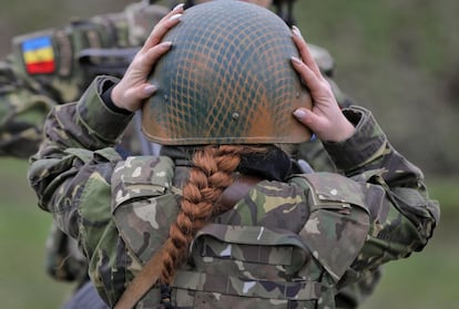 Una mujer del ejército rumano ajusta su casco antes de comenzar un entrenamiento junto a marines estadounidenses en la costa del Mar Negro, en Rumanía.