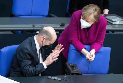 La canciller alemana, Angela Merkel, habla con el ministro de finanzas, Olaf Scholz, durante la sesión del Bundestag de este jueves.
