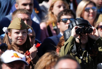 Dos niños observan el desfile del Día de la Victoria entre el público en la Plaza Roja de Moscú.