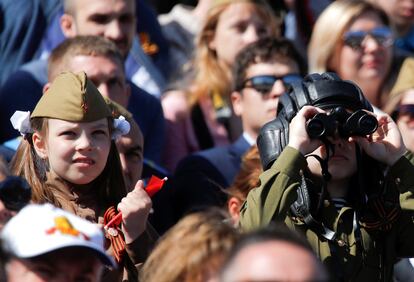 Dos niños observan el desfile del Día de la Victoria entre el público en la Plaza Roja de Moscú.