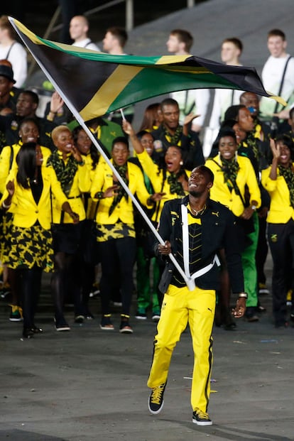 Con un chndal de los ms estiloso, el plusmarquista jamaicano Usain Bolt onde su bandera por todo el estadio olmpico.