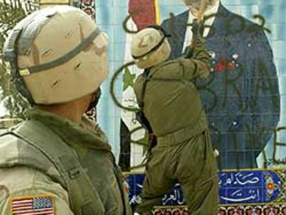 Un militar destruye con un mazo un mural de Sadam Husein en Kerbala.