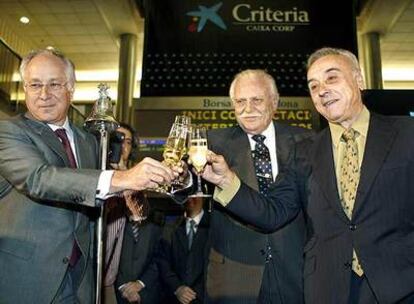 El presidente de Criteria junto al director general de La Caixa y el presidente de la Bolsa de Barcelona brindan en la salida al parqué de la empresa.