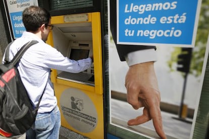 Un ciutadà utilitza un caixer automàtic de CaixaBank a Madrid.