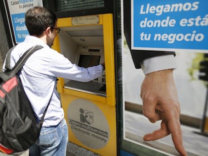 Un ciudadano utiliza un cajero automático de CaixaBank en Madrid. Samuel Sanchez