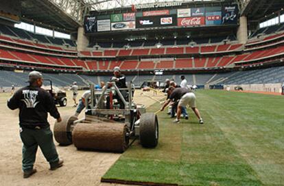 Unos operarios preparan el césped del Reliant Stadium, de Houston.