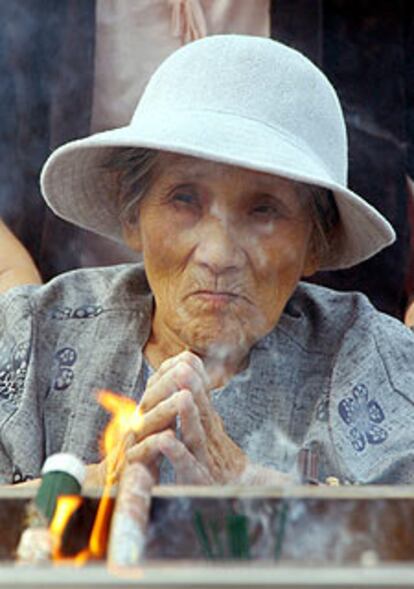 Una anciana reza frente al monumento dedicado a las víctimas de la bomba atómica en el Parque de la Paz durante el 59º aniversario de la catástrofe de Hiroshima.