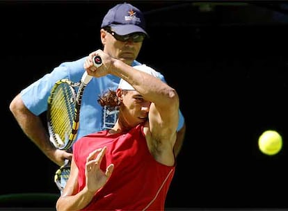 Rafa Nadal golpea con decisión la bola ante la atenta mirada de su tío Toni.