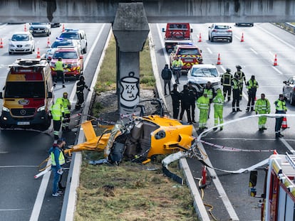 Bomberos, policía y servicios de emergencias, junto al helicóptero siniestrado en la M-40.