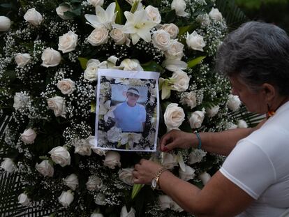 Una mujer coloca la fotografía del periodista Jaime Vásquez en un arreglo floral durante un homenaje en el parque Santander, en Cúcuta.