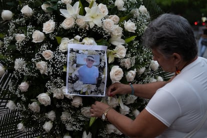 Una mujer coloca la fotografía del periodista Jaime Vásquez en un arreglo floral durante un homenaje en el parque Santander, en Cúcuta.