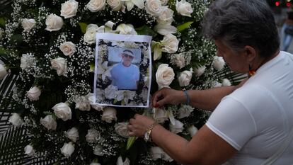 Una mujer coloca la fotografía del periodista Jaime Vásquez en un arreglo floral durante un homenaje en el parque Santander, en Cúcuta.