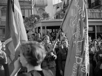 Gerda Taro, de espaldas, fotografiada mientras capturaba con su c&aacute;mara el funeral del general Lukacs, en Valencia, el 12 de junio de 1937.