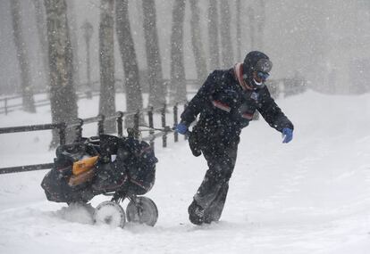 Un cartero tira de su carrito a través de la nieve en Brooklyn, Nueva York (EE UU).