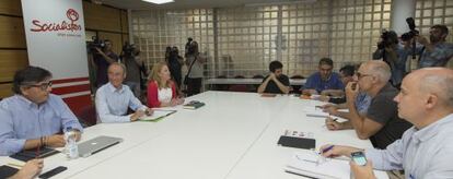 La comisión negociadora del PSPV, a la izquierda, con la de Compromís en la sede socialista.