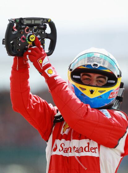 Alonso señala victorioso su volante tras el triunfo.