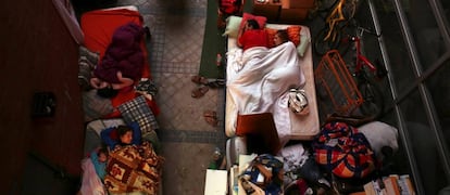 Una familia duerme junto a la vivienda de la que han sido desahuciados, en Madrid en 2013.