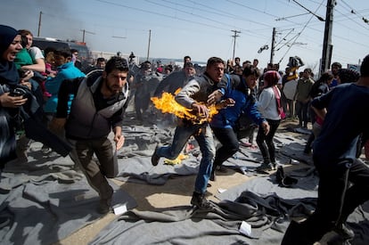 Un hombre corre después de inmolarse durante una protesta en un campamento improvisado en la frontera entre Grecia y Macedonia, cerca de la localidad griega de Idomeni.
