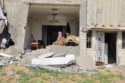 Una mujer observa el salón de su vivienda destruida tras regresar al inicio de la tregua, este domingo, en Ciudad de Gaza.