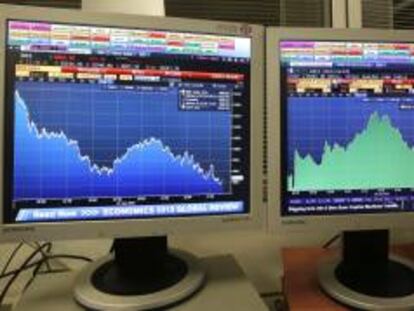 Pantallas que muestran la evolución del índice de referencia del mercado nacional, IBEX 35 (i), y la prima de riesgo. EFE/Archivo