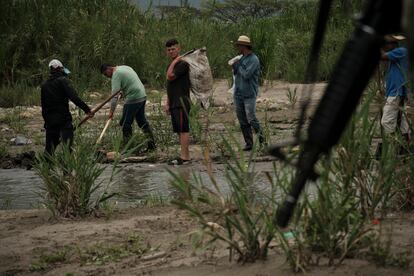 People work on the trails near the Táchira river while the Colombian army patrols the area, on March 29.