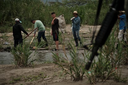 People work on the trails near the Táchira river while the Colombian army patrols the area, on March 29.