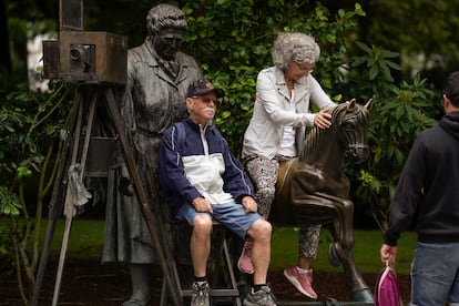 Unos turistas se hacen fotos sentados en la estatua de La Torera, este martes en Oviedo.