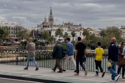 Viandantes pasean por Sevilla en manga corta y abrigos, lo que muestra el tiempo cambiante que sufre la ciudad, esta semana.