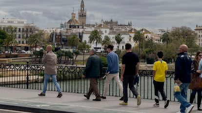 Viandantes pasean por Sevilla en manga corta y abrigos, lo que muestra el tiempo cambiante que sufre la ciudad, esta semana.