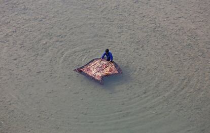 Un hombre lava una manta en el río Tawi, en Jammu (India).