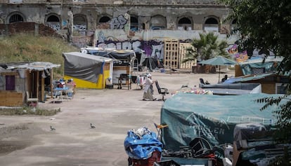 Una mujer traslada una silla en el campamento de la calle Bilbao.