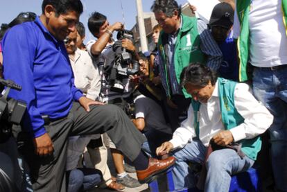 El candidato Alejandro Toledo lustra los zapatos de uno de sus seguidores en un mitin en Arequipa.