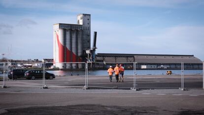 Tres operarios caminan por la zona de aparcamiento de los astilleros de Saint-Nazaire, en diciembre.